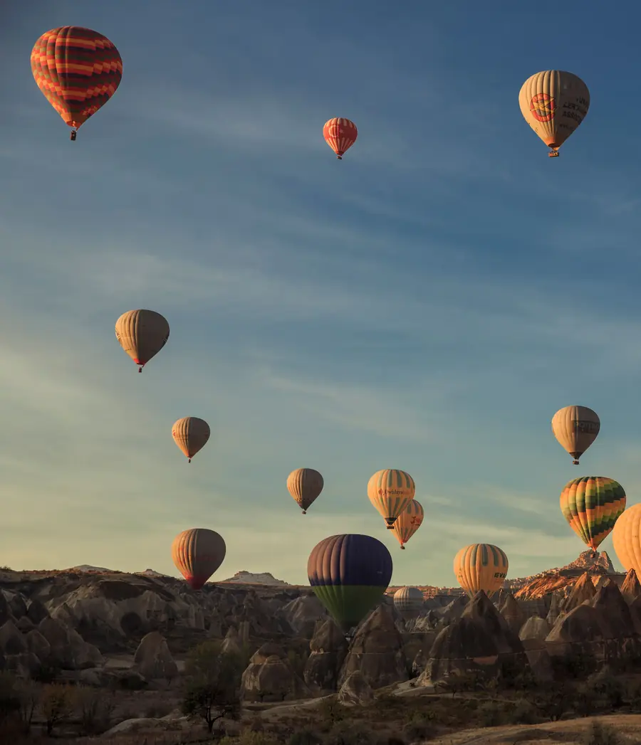 Balloons over the valley with Uçhisar on the horizon